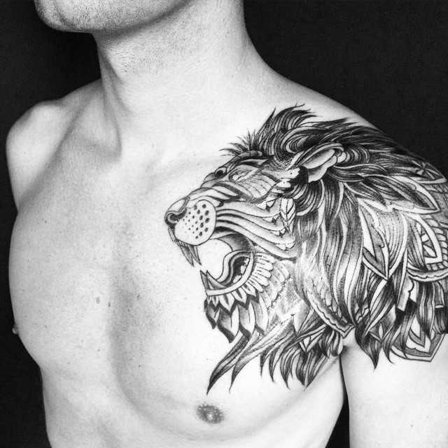 Тату лев в стиле орнаментал на плече мужчины